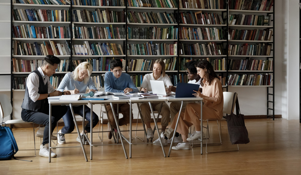 54676985-group-of-multiracial-students-sit-at-table-in-library.jpg